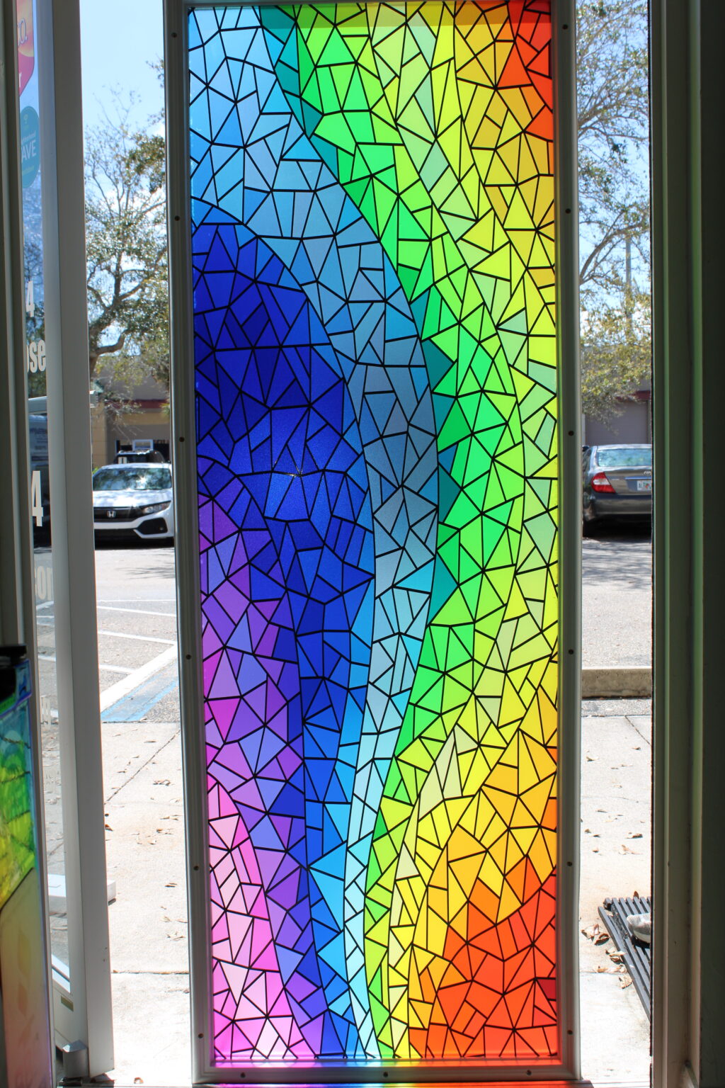 Vibrant rainbow stained-glass style decorative window film with mosaic geometric design.