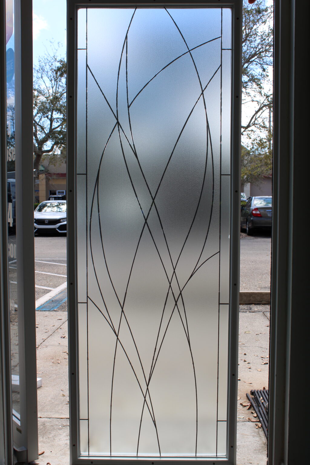 Frosted glass film featuring intricate clear linework in an abstract wave design.
