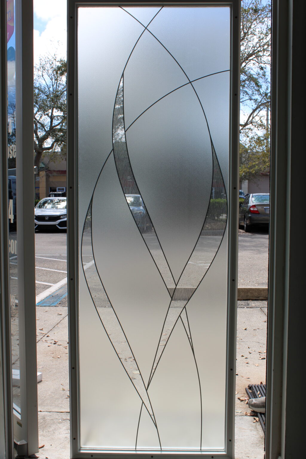 Decorative frosted glass panel with textured clear curved patterns for an elegant privacy solution.