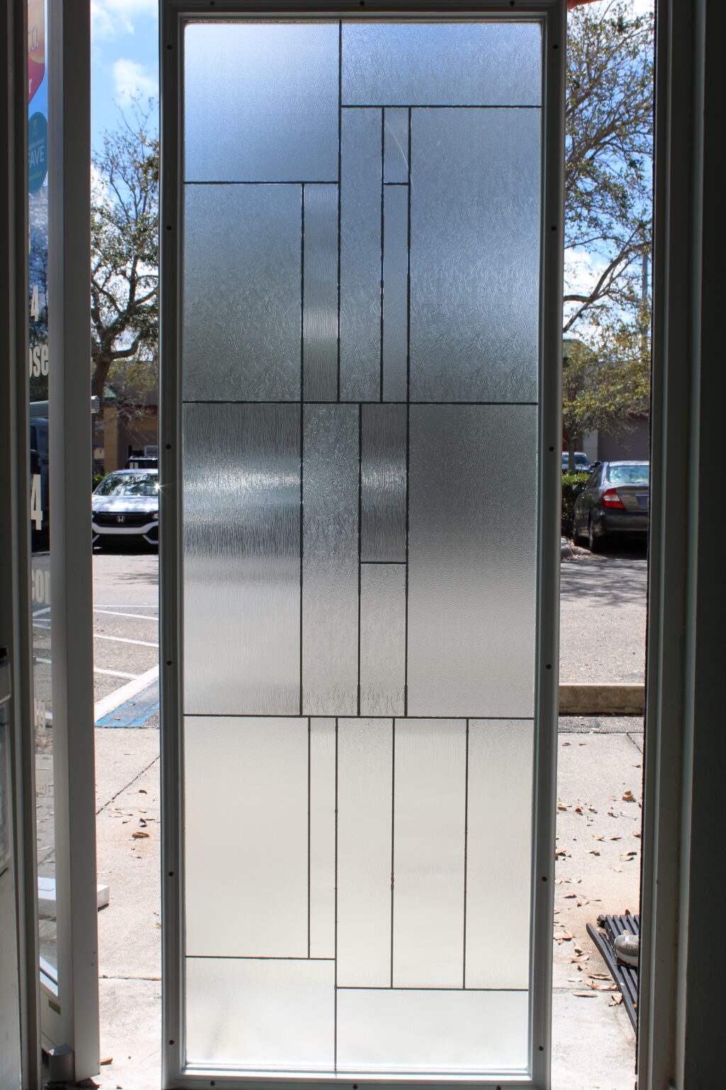 Decorative frosted glass film with a geometric block pattern of textured and clear panels for a modern, stylish look.
